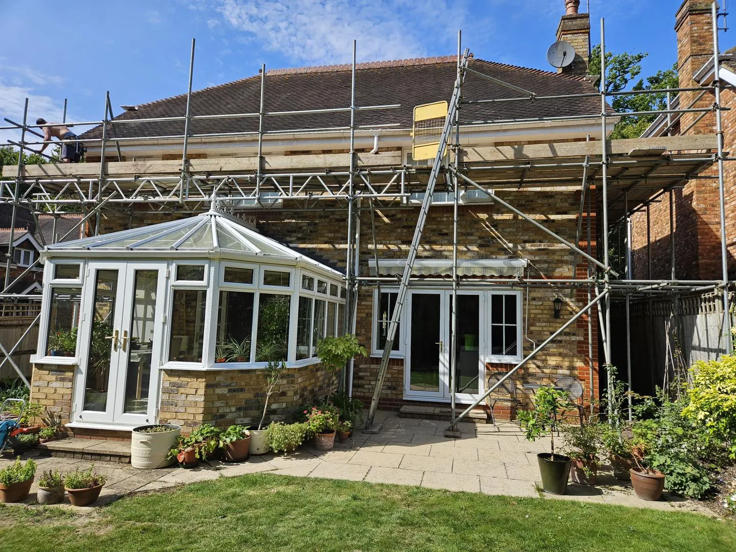 A house under construction with scaffolding on the roof.