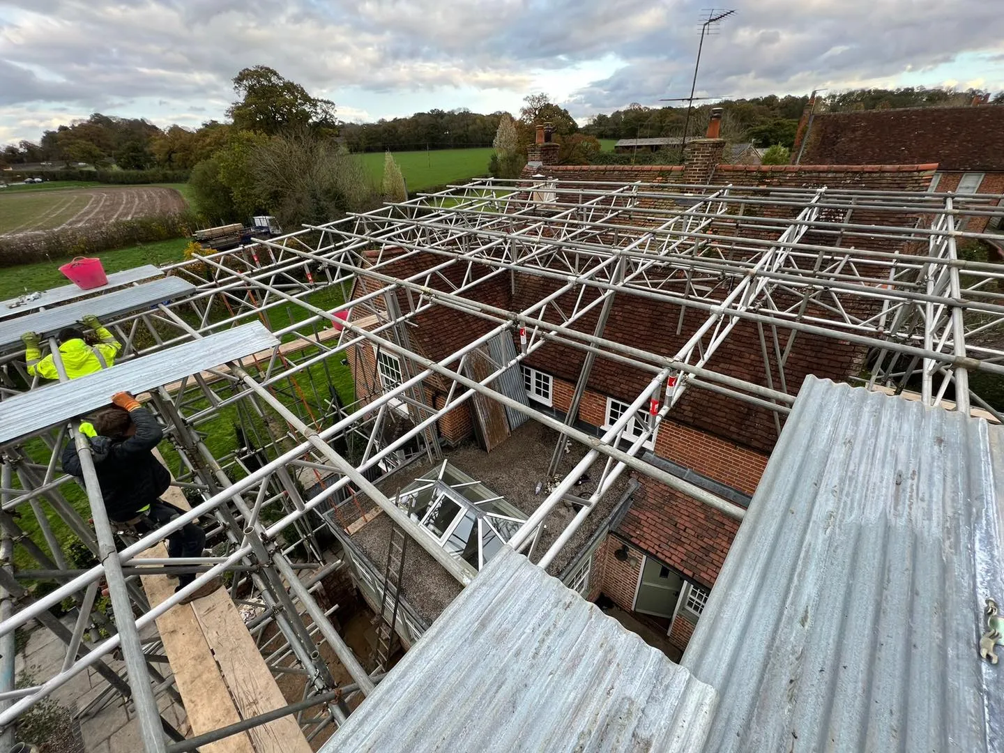 A group of men standing on top of a metal roof.