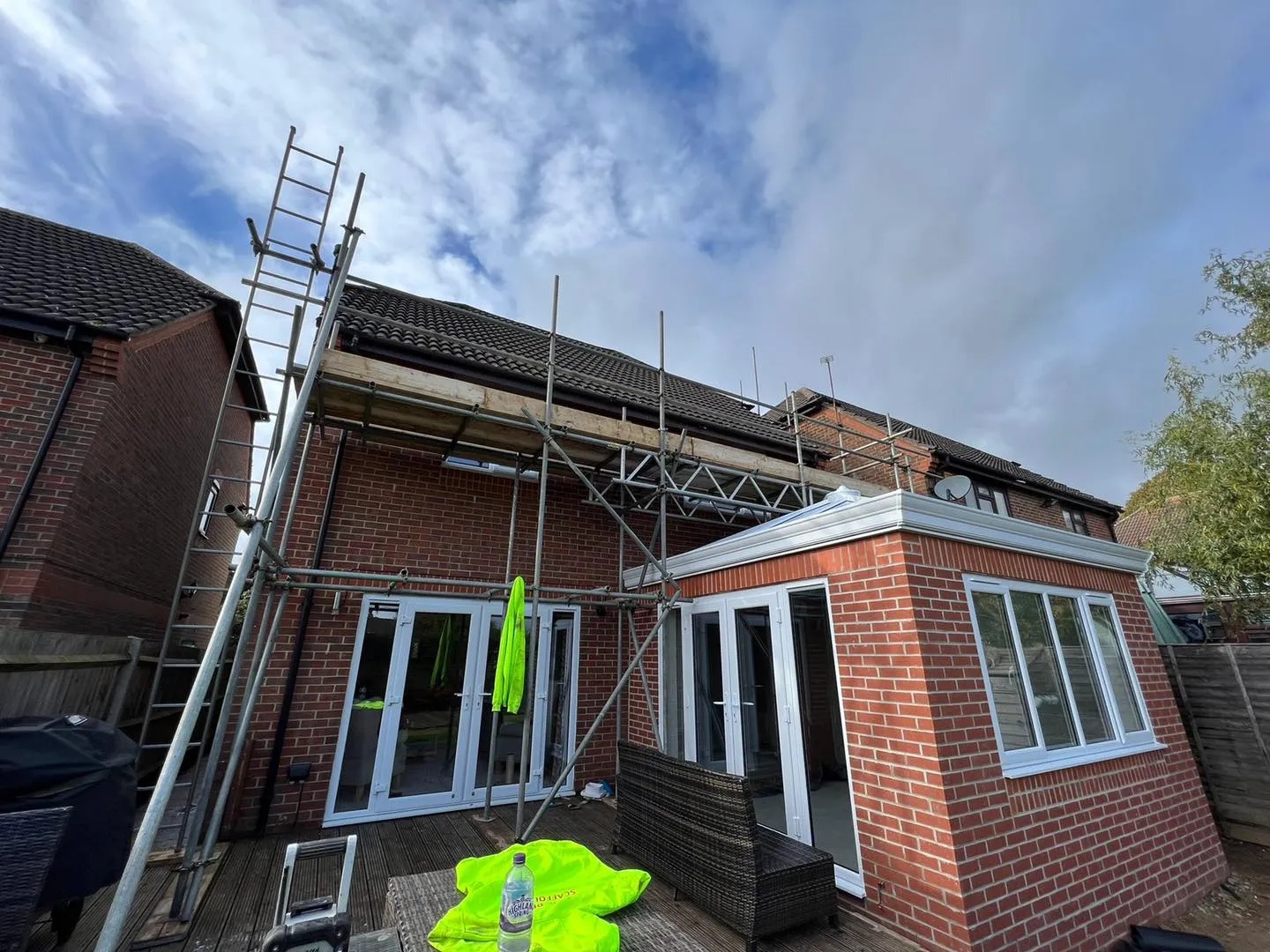 A house under construction with scaffolding on the roof.